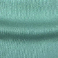 Gros plan sur Tissu en lyocell denim multicolore au mètre de Longan Craft France : denim lyocell durable vert clair avec un tissage diagonal subtil et un pli horizontal visible, parfait pour des jeans respirants et confortables.