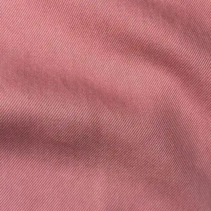 Gros plan sur le tissu en lyocell denim multicolore au mètre de Longan Craft France, montrant sa fine armure sergée diagonale. Ce sergé de lyocell doux, respirant et durable est idéal pour les jeans confortables et se caractérise par des plis et des ombres délicats.