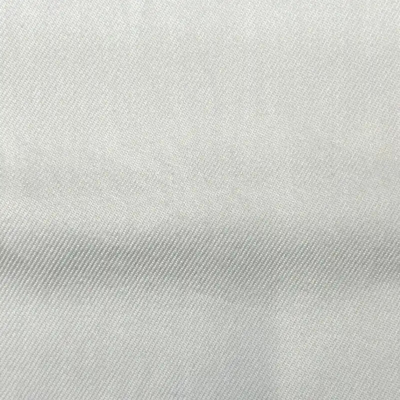 Gros plan sur le tissu en lyocell denim multicolore au mètre de Longan Craft France, montrant sa couleur claire, son tissage subtil en diagonale et son pli léger. Ce sergé lyocell respirant et confortable est idéal pour les jeans.