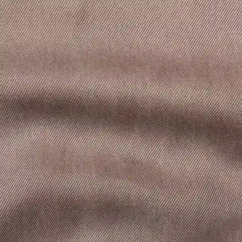 Gros plan sur Tissu en lyocell denim multicolore au mètre de Longan Craft France, montrant un denim sergé brun clair, durable, avec un tissage sergé diagonal et une texture visible - légèrement froissé, respirant et confortable pour les jeans.