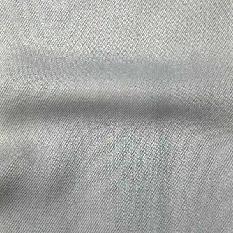 Gros plan sur le Tissu en lyocell denim multicolore au mètre de Longan Craft France, montrant son motif sergé gris clair et lisse. Ce textile en lyocell, respirant et confortable, présente un subtil sergé diagonal et une ombre horizontale.