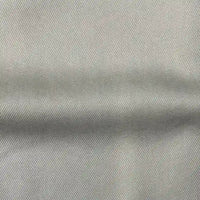 Un gros plan du tissu en lyocell denim multicolore au mètre de Longan Craft France montre son tissage sergé gris clair et son pli, mettant en valeur ce textile respirant et confortable, idéal pour les jeans.