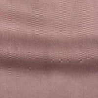 Gros plan sur le tissu en lyocell denim multicolore au mètre de Longan Craft France : un textile en lyocell sergé respirant et confortable, de couleur mauve clair, avec un tissage en diagonale qui présente des ombres subtiles et un léger pli, parfait comme tissu pour jeans.