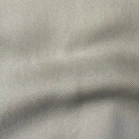 Gros plan sur le tissu en lyocell denim multicolore au mètre de Longan Craft France, qui se caractérise par un tissage sergé diagonal doux et des plis délicats - un textile respirant et confortable en lyocell sergé, idéal pour les jeans modernes.