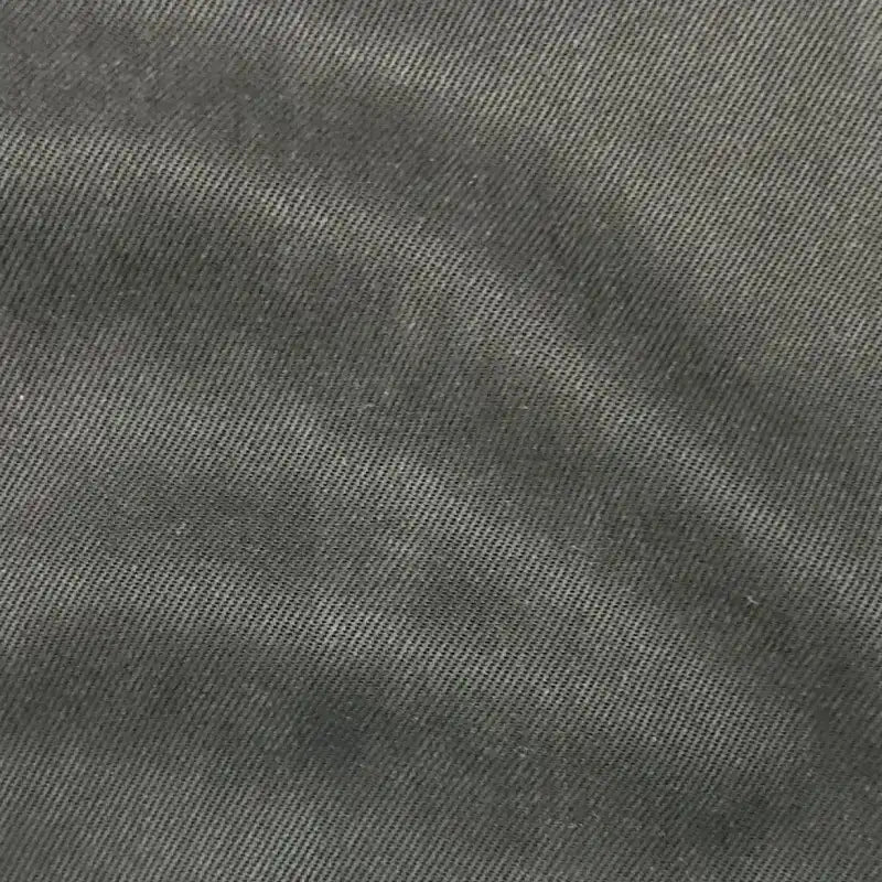 Gros plan sur le tissu en lyocell denim multicolore au mètre de Longan Craft France, révélant sa texture sergée nervurée en diagonale et ses plis subtils - un textile respirant et confortable, idéal pour confectionner des jeans de haute qualité.