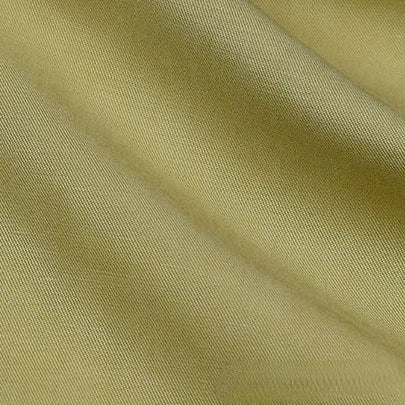 Gros plan sur Tissu lyocell et lin uni au mètre de Longan Craft France, montrant sa texture sergée vert olive clair, lisse et subtilement brillante - un textile infroissable, durable et respirant, idéal pour les peignoirs.