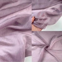 Quatre gros plans montrent le Tissu lin et soie uni au mètre de Longan Craft France. Une main tient le tissu semi-transparent, violet clair, mettant en évidence sa texture fine et aérienne et son aspect doux, légèrement brillant et luxueux, idéal pour les tissus d'ameublement.