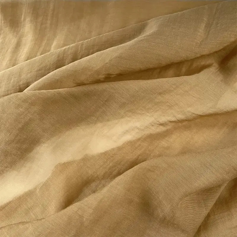 Gros plan sur Tissu lin et soie uni au mètre de Longan Craft France, un fin mélange de lin, de lyocell et de soie aux plis et à la texture subtils, idéal pour l'ameublement et mettant en valeur son luxe raffiné.