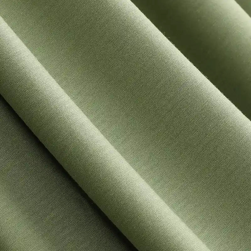 Gros plan sur le Jersey modal uni au mètre vert olive clair de Longan Craft France, un tissu doux et respirant en coton-modal avec un subtil motif à chevrons et une légère brillance - parfait pour les vêtements de nuit et les enfants.