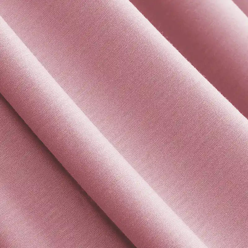 Gros plan sur le Jersey modal uni au mètre, lisse et rose, de Longan Craft France, un tissu coton-modal respirant et finement tissé, idéal pour les vêtements de nuit. Le textile présente des plis délicats et une texture douce, parfaits pour des vêtements de nuit confortables.