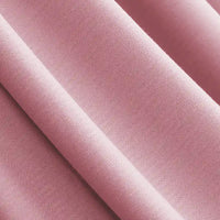 Gros plan sur le Jersey modal uni au mètre, lisse et rose, de Longan Craft France, un tissu coton-modal respirant et finement tissé, idéal pour les vêtements de nuit. Le textile présente des plis délicats et une texture douce, parfaits pour des vêtements de nuit confortables.