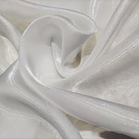 Gros plan sur le tissu organza uni au mètre de Longan Craft France, qui présente des plis blancs chatoyants et une texture lisse et translucide - idéal pour vêtements et décoration.