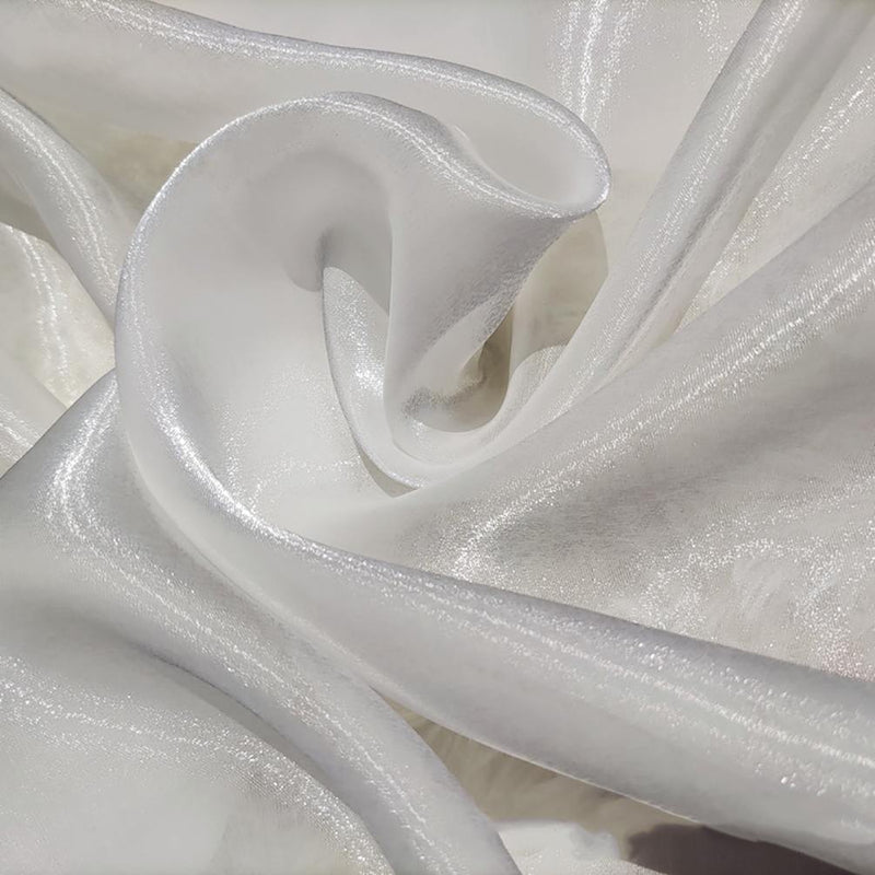 Gros plan sur le tissu organza uni au mètre de Longan Craft France, qui présente des plis blancs chatoyants et une texture lisse et translucide - idéal pour vêtements et décoration.