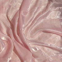Tissu organza uni au mètre de Longan Craft France : tissu semi-transparent, rose pâle, léger et brillant, parfait pour l'habillement ou la décoration. Il se drape en douceur et accroche magnifiquement la lumière.