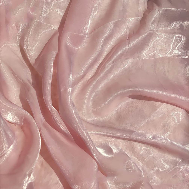 Tissu organza uni au mètre de Longan Craft France : tissu semi-transparent, rose pâle, léger et brillant, parfait pour l'habillement ou la décoration. Il se drape en douceur et accroche magnifiquement la lumière.