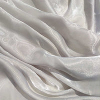 Gros plan sur le tissu organza uni au mètre de Longan Craft France : léger, transparent et légèrement brillant en blanc, avec de douces ondulations-idéal pour vêtements ou décoration.