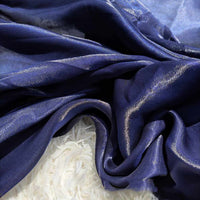 Gros plan sur l'organza Tissu léger et transparent uni au mètre de Longan Craft France, drapé en plis souples sur une surface texturée blanche - parfait pour l'habillement et la décoration.