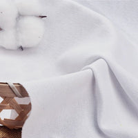 Gros plan sur le Tissu piqué uni au mètre-coton-polyester pour polos de Longan Craft France, drapé sur un panier avec une balle de coton, mettant en valeur le tissage distinctif et la finition lisse du tissu, idéal pour les chemises et les polos d'été DIY.