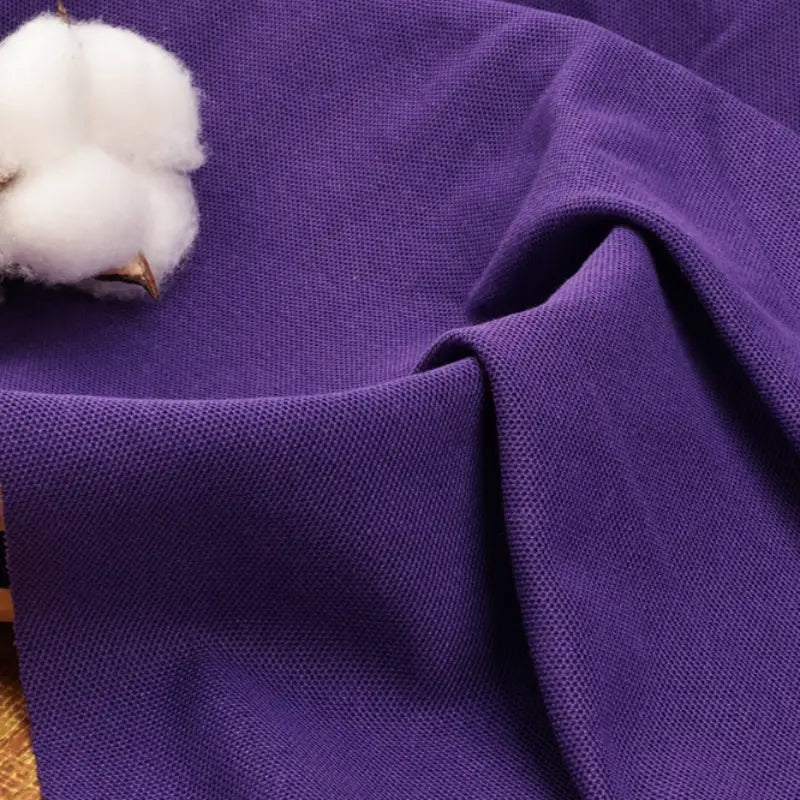 Un gros plan sur le Tissu piqué uni au mètre de Longan Craft France - un tissu coton-polyester pour polos et chemises d'été - montre son tissage fin et sa qualité, parfaits pour les chemises ou polos manches courtes d'été DIY.