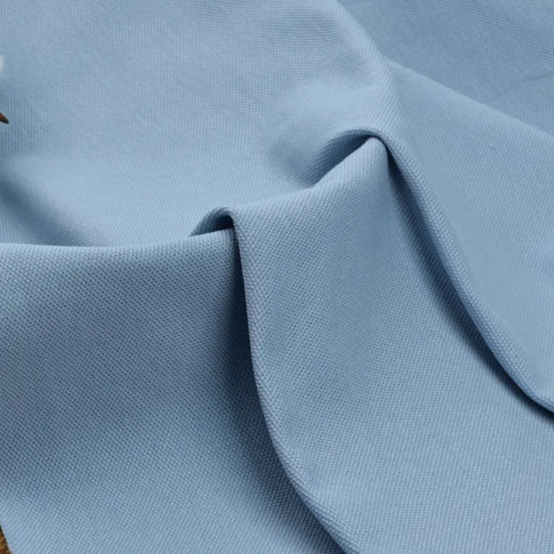 Le Tissu piqué uni au mètre bleu clair de Longan Craft France présente un tissage fin et subtil pour un toucher doux et légèrement épais, idéal pour les polos et les chemises d'été. Pas de motifs visibles ; parfait pour les projets de bricolage à manches courtes.