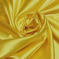 Gros plan sur le Tissu satin polyester uni au mètre de Longan Craft France, disposé en plis tourbillonnants - sa surface brillante et extensible est parfaite pour des vêtements ajustés et confortables ou comme tissu pour robes.