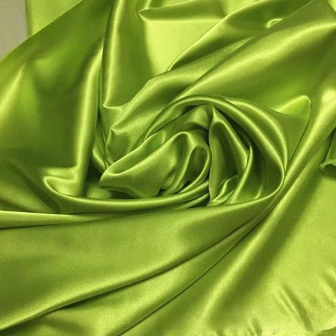 Un gros plan du tissu satin polyester uni au mètre de Longan Craft France révèle sa surface lisse, brillante et légèrement ridée de couleur vert lime - idéale comme matière extensible en satin pour vêtements ajustés et confortables.
