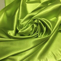 Un gros plan du tissu satin polyester uni au mètre de Longan Craft France révèle sa surface lisse, brillante et légèrement ridée de couleur vert lime - idéale comme matière extensible en satin pour vêtements ajustés et confortables.