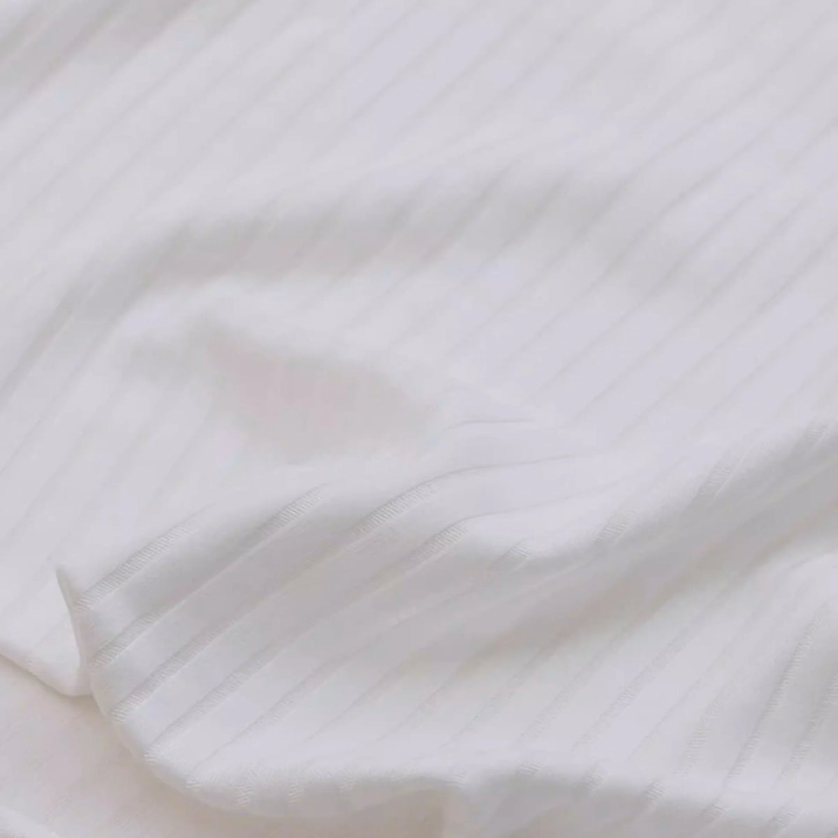 Un gros plan du Tissu côtelé uni en viscose au mètre de Longan Craft France montre sa texture douce et subtilement nervurée. Ce textile confortable et extensible en viscose mélangée est idéal pour les projets de t-shirts et de peignoirs DIY.