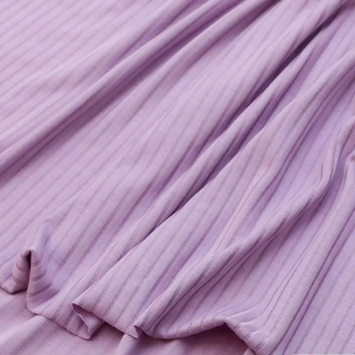 Gros plan sur le tissu côtelé uni en viscose au mètre de Longan Craft France, un textile confortable et extensible grâce à l'élasthanne, parfait pour les t-shirts DIY.