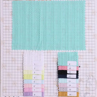 Un grand échantillon de tissu bleu clair rayé uni au mètre de Longan Craft France est présenté au-dessus d'une grille. Seize plus petits échantillons numérotés, comprenant des options de ratière jacquard 100 % coton, sont affichés en dessous.