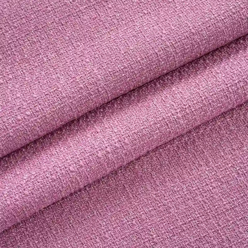 Gros plan sur le Tissu tweed uni au mètre de Longan Craft France : tweed de polyester texturé rose avec une finition tissée légèrement rugueuse et de petites bosses en relief - un tweed textile chic parfait pour les costumes et les vêtements.
