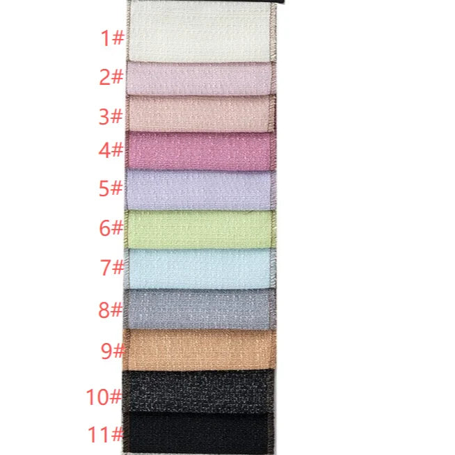 Une pile verticale de onze échantillons rectangulaires de Tissu tweed uni au mètre de Longan Craft France, étiquetés de 1# à 11# en rouge sur la gauche ; chaque textile de polyester présente une finition chic, légèrement brillante ou texturée pour les vêtements.