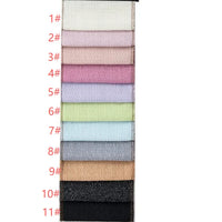 Une pile verticale de onze échantillons rectangulaires de Tissu tweed uni au mètre de Longan Craft France, étiquetés de 1# à 11# en rouge sur la gauche ; chaque textile de polyester présente une finition chic, légèrement brillante ou texturée pour les vêtements.