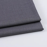Deux pièces de Tissu gabardine uni au mètre de Longan Craft France, de couleur gris moyen, sont empilées sur une surface blanche. Lisse et tissé serré, ce mélange laine-rayon-polyester est parfait pour les vêtements décontractés et les créations sur mesure.