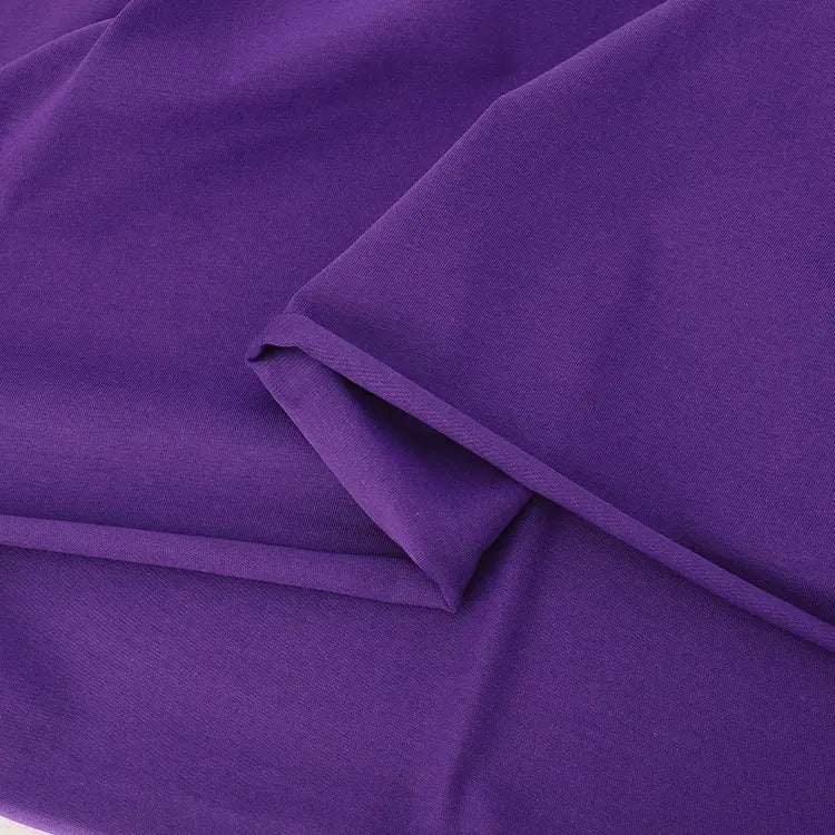 Gros plan sur un tissu violet lisse et plié, aux bords nets et aux plis minimes - idéal pour le Jersey coton élasthanne au mètre de Longan Craft France, un jersey extensible parfait pour les peignoirs et les vêtements.