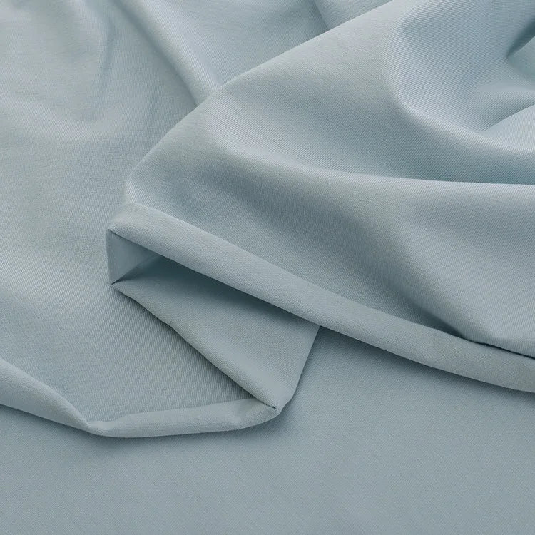 Le Jersey coton élasthanne au mètre de Longan Craft France est un tissu lisse, doux et extensible idéal pour la confection de robes. Il se caractérise par sa couleur bleu clair et son aspect légèrement drapé.