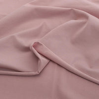 Le Jersey coton élasthanne au mètre de Longan Craft France est un tissu extensible rose clair uni, à la texture lisse et douce et aux plis subtils. Cet uni tissu jersey est idéal pour des robes et vêtements confortables sans motifs ni ornements.