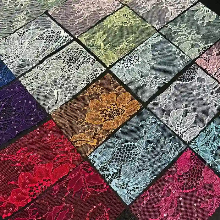 Des échantillons rectangulaires de Tissu dentelle pailleté avec sequins au mètre de Longan Craft France, dans les coloris rouge, blanc, jaune, violet, bleu, vert et rose, sont disposés dans une grille. Chacun d'entre eux présente des motifs floraux et une texture délicate en filet.