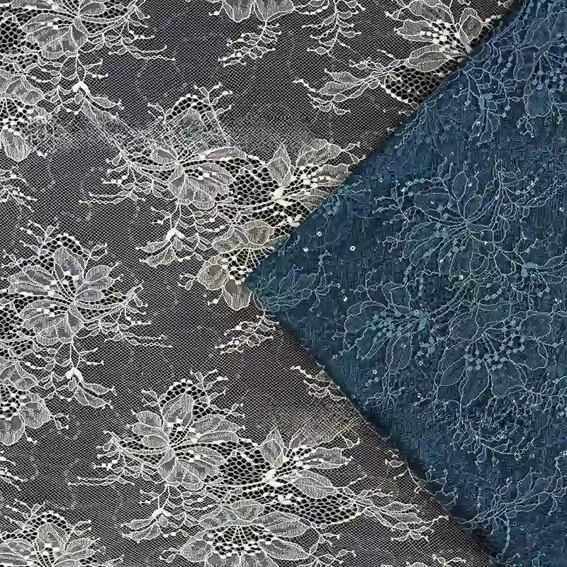 Deux pièces de tissu dentelle pailleté avec paillettes au mètre de Longan Craft France sont exposées : l'une noire avec des motifs floraux blancs, l'autre bleu marine, toutes deux se chevauchant partiellement et disposées en diagonale pour des projets de peignoirs et de lingerie.