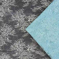 Deux Tissu dentelle pailleté avec sequins au mètre de Longan Craft France sont présentés : l'un noir avec broderie blanche, l'autre bleu clair. Les deux tissus sont des dentelles de qualité, parfaites pour les peignoirs ou la lingerie, disposées en biais l'une par rapport à l'autre.