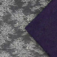 Une dentelle florale blanche transparente est superposée au Tissu dentelle pailleté avec paillettes au mètre de Longan Craft France, tous deux dotés de motifs complexes. La dentelle est semi-transparente, tandis que le tissu à paillettes semble plus opaque.
