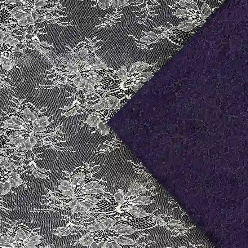 Une dentelle florale blanche transparente est superposée au Tissu dentelle pailleté avec paillettes au mètre de Longan Craft France, tous deux dotés de motifs complexes. La dentelle est semi-transparente, tandis que le tissu à paillettes semble plus opaque.