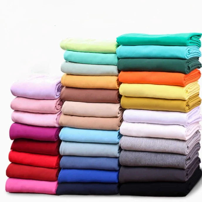 Trois piles de Tissu French Terry en coton extensible de Longan Craft France sont soigneusement disposées sur un fond blanc - confortable, multicolore et idéal pour les vêtements de sport, vendus au mètre.