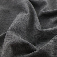 Gros plan sur un tissu multicolore, doux et extensible en coton French Terry de Longan Craft France, idéal pour les vêtements de sport. Tissu French Terry en coton extensible au mètre, montrant texture et plis confortables.