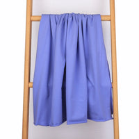 Un morceau de Tissu French Terry en coton extensible au mètre de Longan Craft France repose sur une échelle en bois clair, devant un mur texturé blanc-parfait pour des vêtements de sport confortables.