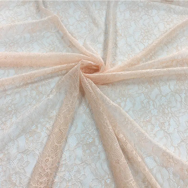 Tissu dentelle extensible au mètre, par Longan Craft France, présenté à plat avec motif floral et plis centraux étoilés. Cette dentelle multicolore de haute qualité est délicate, idéale pour vêtements, lingerie et jupes.