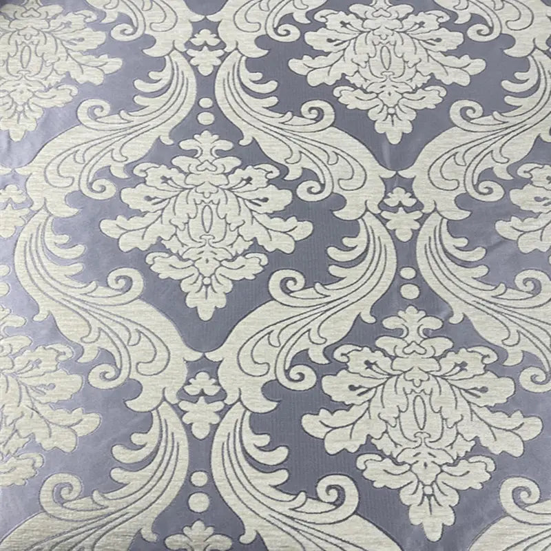 Gros plan sur le Tissu chenille damassé épais au mètre de Longan Craft France, un tissu d'ameublement jacquard épais avec un damas floral crème orné sur un fond gris-lavande - idéal pour une décoration intérieure élégante et des projets d'inspiration vintage.