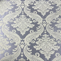 Gros plan sur le Tissu chenille damassé épais au mètre de Longan Craft France, un tissu d'ameublement jacquard épais avec un damas floral crème orné sur un fond gris-lavande - idéal pour une décoration intérieure élégante et des projets d'inspiration vintage.