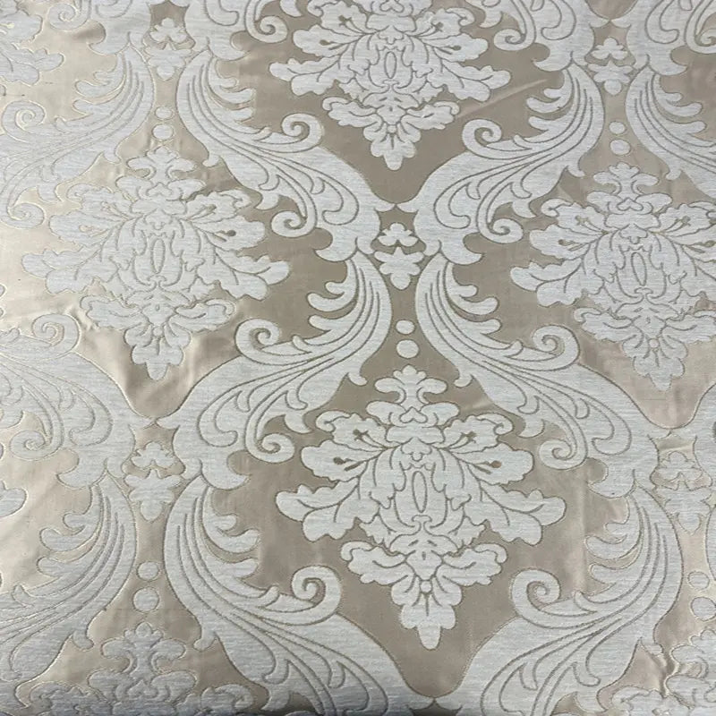 Un gros plan du Tissu chenille damassé épais au mètre de Longan Craft France montre son tissu jacquard beige avec des motifs blancs ornés d'inspiration vintage, idéal comme tissu d'ameublement élégant pour les projets de décoration d'intérieur.