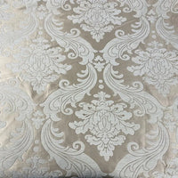 Un gros plan du Tissu chenille damassé épais au mètre de Longan Craft France montre son tissu jacquard beige avec des motifs blancs ornés d'inspiration vintage, idéal comme tissu d'ameublement élégant pour les projets de décoration d'intérieur.